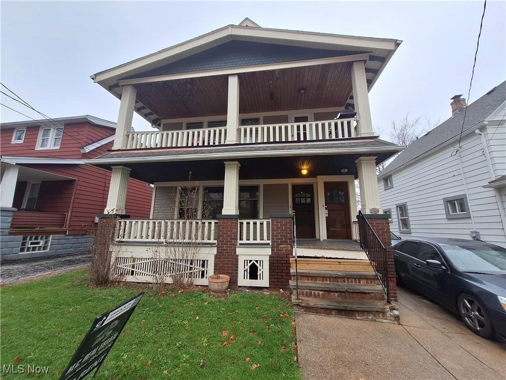 view of front facade featuring a balcony, a porch, and a front yard