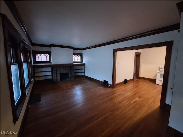 unfurnished living room featuring hardwood / wood-style floors, ornamental molding, and a brick fireplace