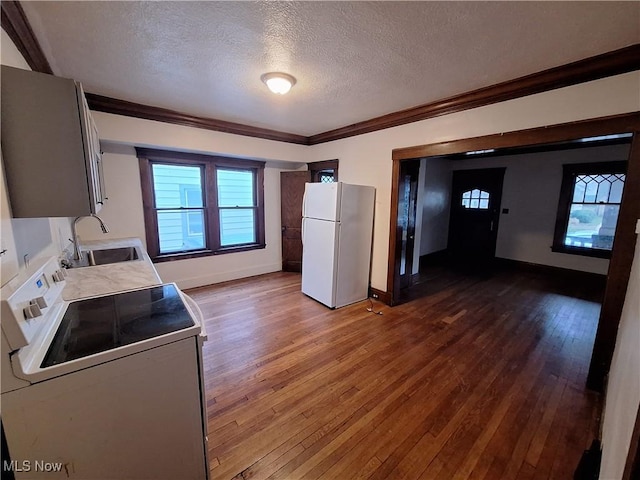 kitchen with sink, dark hardwood / wood-style flooring, crown molding, a textured ceiling, and white appliances