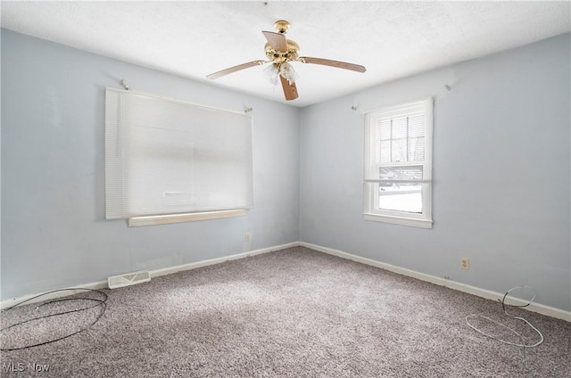 carpeted spare room featuring ceiling fan