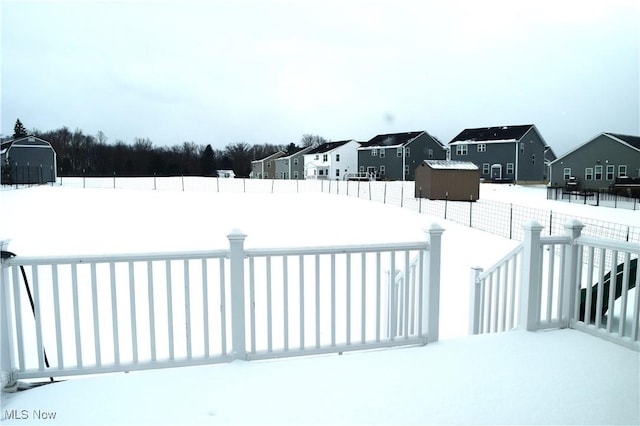 yard layered in snow featuring a storage shed