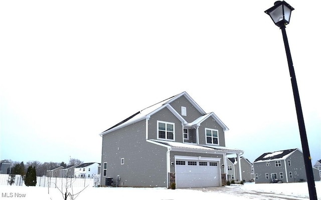 view of snow covered exterior with a garage