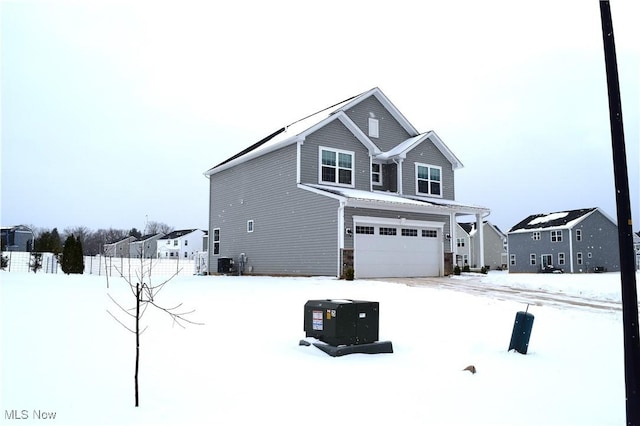 snow covered property featuring a garage