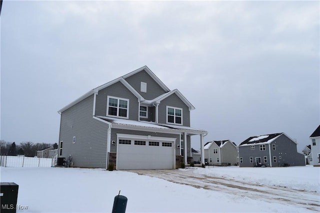 view of front of property featuring central air condition unit and a garage