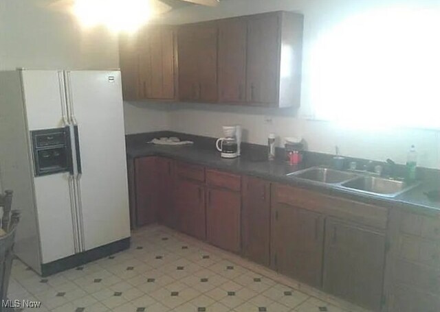 kitchen featuring white refrigerator with ice dispenser and sink