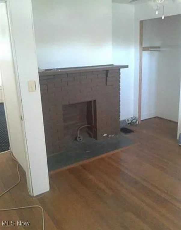 details featuring a brick fireplace, hardwood / wood-style flooring, and ceiling fan