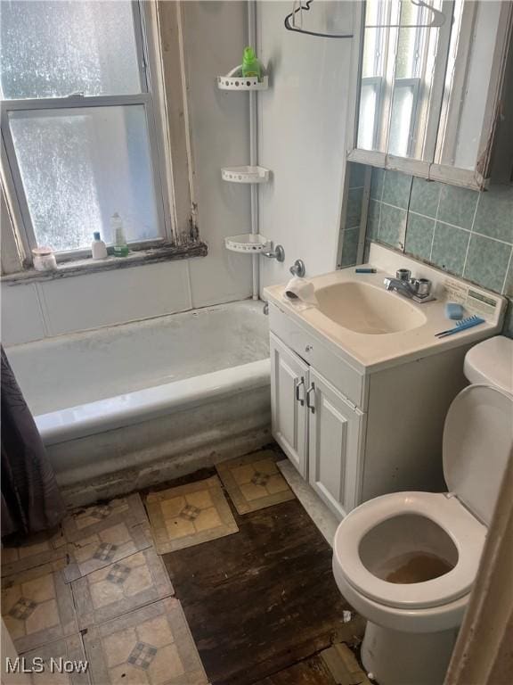 full bathroom featuring shower / bath combination with curtain, backsplash, toilet, and a wealth of natural light