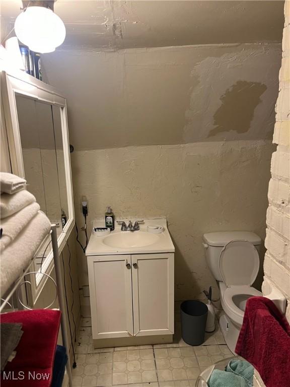 bathroom with vanity, toilet, and vaulted ceiling