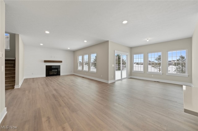 unfurnished living room featuring a textured ceiling and light wood-type flooring