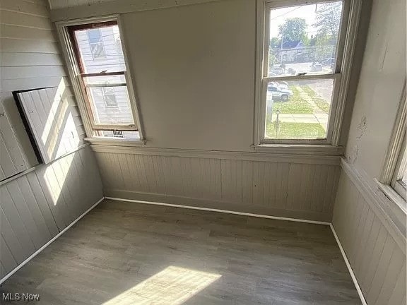 spare room featuring a wainscoted wall and wood finished floors