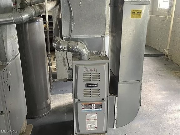 utility room featuring heating unit and gas water heater