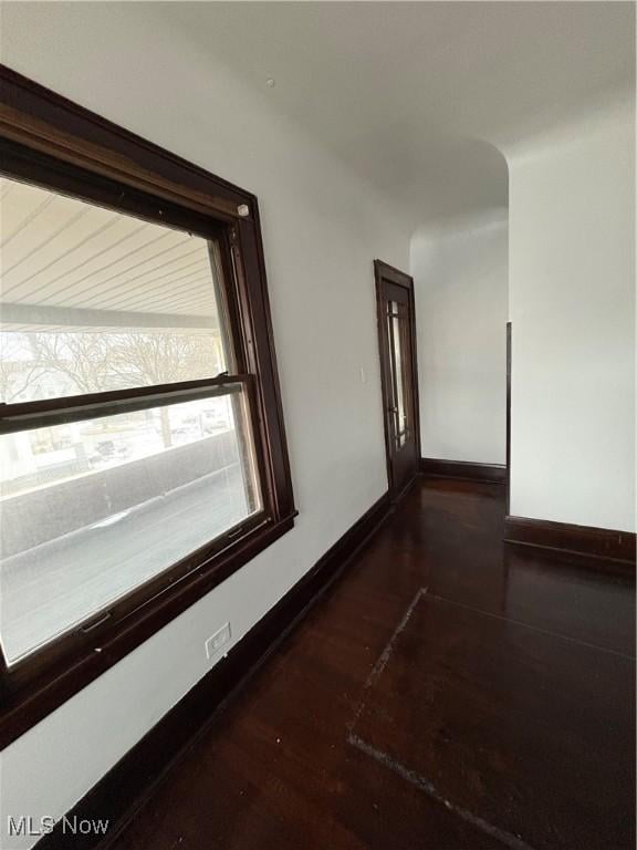 hall featuring dark wood finished floors and baseboards