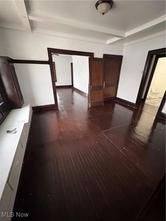 corridor with baseboards, dark wood finished floors, and beamed ceiling