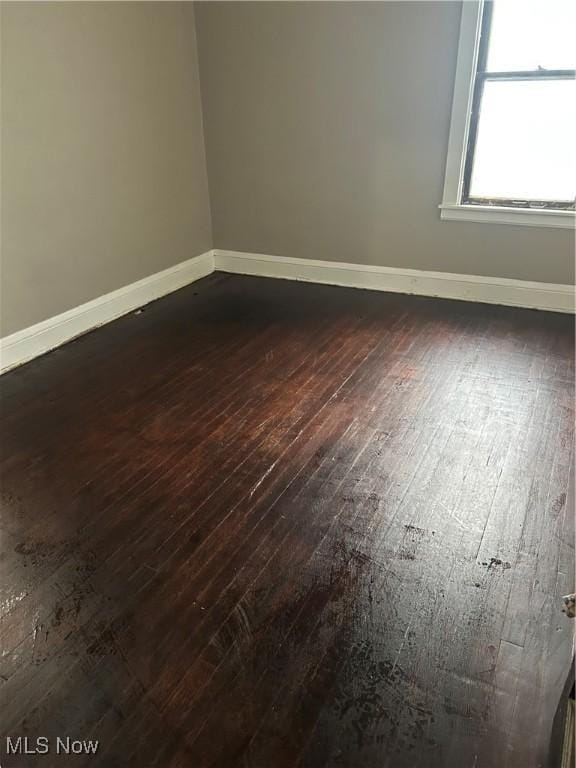 unfurnished room featuring dark wood finished floors and baseboards