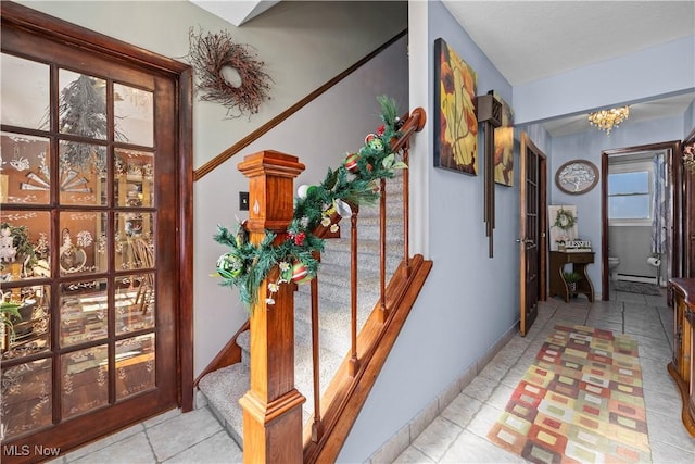 corridor featuring a baseboard radiator and a chandelier