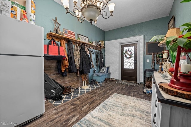 mudroom featuring a notable chandelier, dark hardwood / wood-style flooring, and a textured ceiling