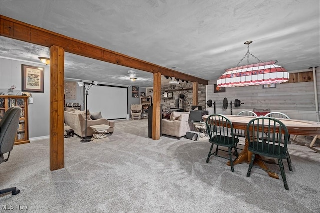 dining space featuring wood walls, light colored carpet, and vaulted ceiling