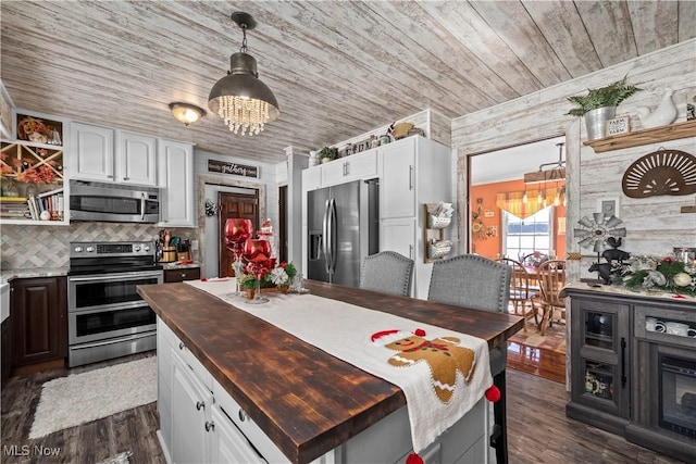 kitchen with white cabinets, appliances with stainless steel finishes, a center island, and wood ceiling