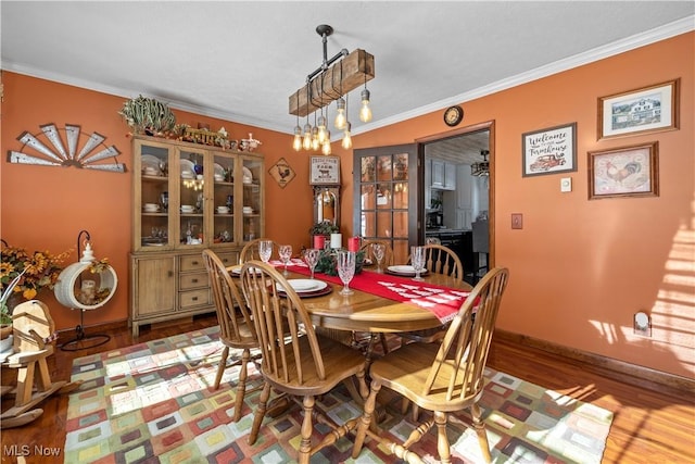 dining area featuring ornamental molding and hardwood / wood-style flooring