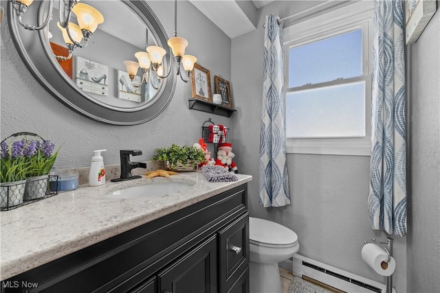 bathroom with a chandelier, vanity, toilet, and baseboard heating