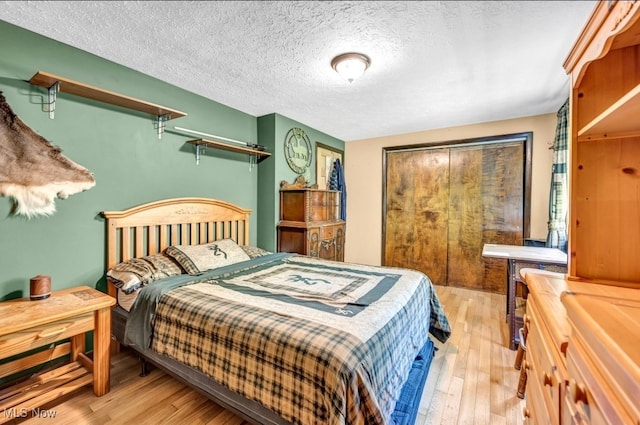 bedroom featuring light wood-type flooring and a textured ceiling