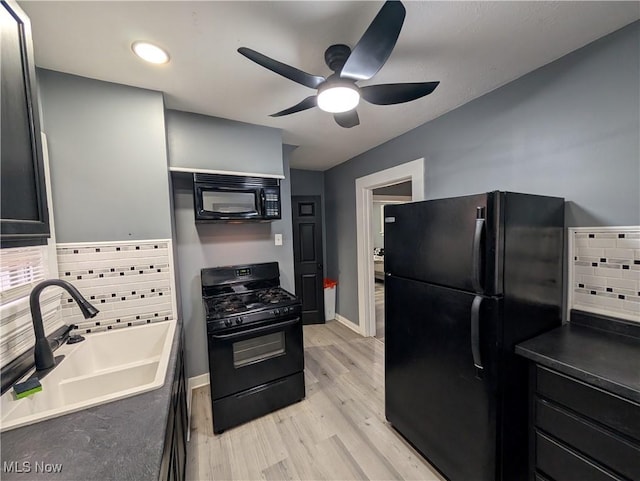 kitchen with decorative backsplash, ceiling fan, sink, black appliances, and light hardwood / wood-style floors