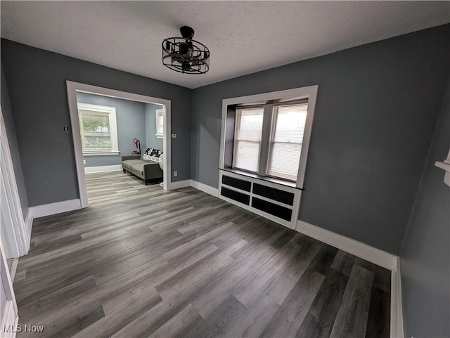 unfurnished dining area featuring hardwood / wood-style floors and a textured ceiling