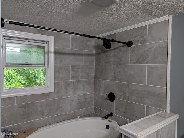 bathroom featuring tiled shower / bath combo and a textured ceiling