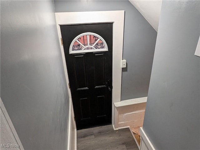 doorway to outside featuring hardwood / wood-style floors and vaulted ceiling