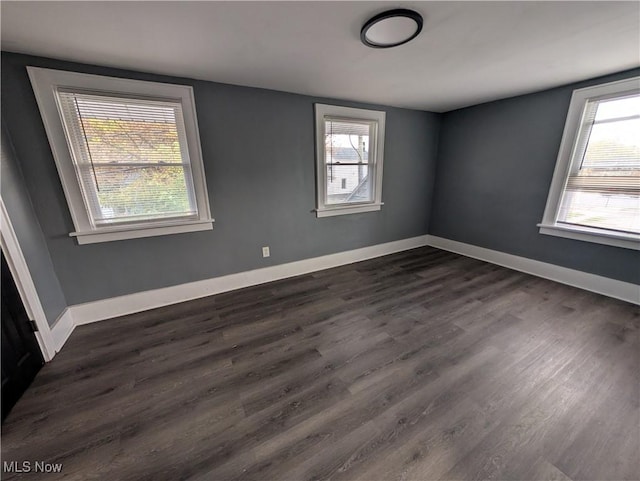 empty room with dark hardwood / wood-style flooring