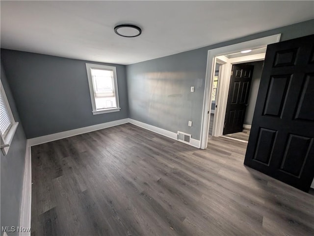 unfurnished room with dark wood-type flooring