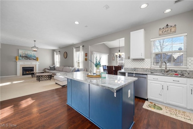 kitchen with a center island, dishwasher, white cabinets, and pendant lighting