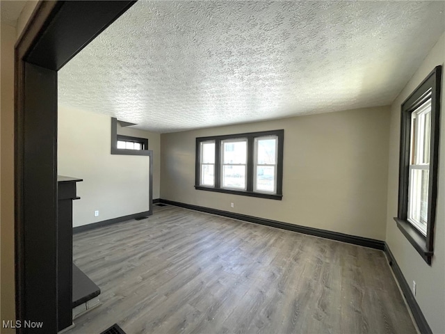 unfurnished living room featuring light hardwood / wood-style floors and a textured ceiling