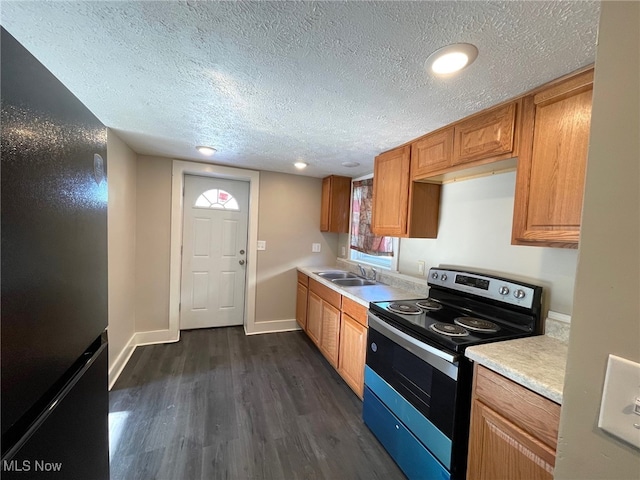 kitchen with sink, dark wood-type flooring, black fridge, a textured ceiling, and stainless steel electric range