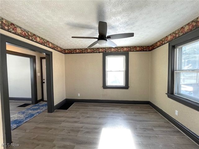 unfurnished room with hardwood / wood-style floors, ceiling fan, and a healthy amount of sunlight