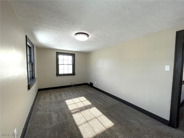 carpeted spare room with a textured ceiling