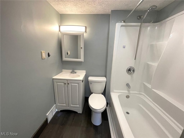 full bathroom featuring hardwood / wood-style floors, a textured ceiling, toilet, shower / tub combination, and vanity