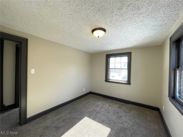 carpeted empty room featuring a textured ceiling