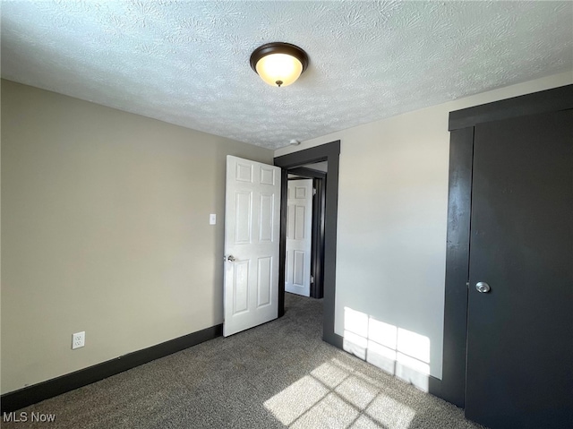 unfurnished bedroom featuring carpet floors and a textured ceiling