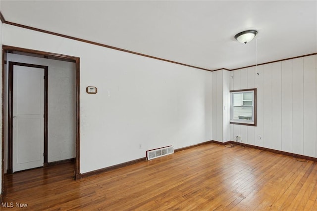 unfurnished room featuring crown molding and wood-type flooring