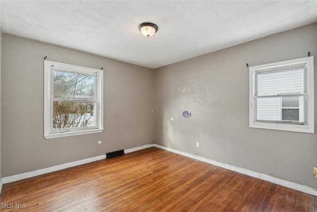 spare room with hardwood / wood-style floors and a textured ceiling