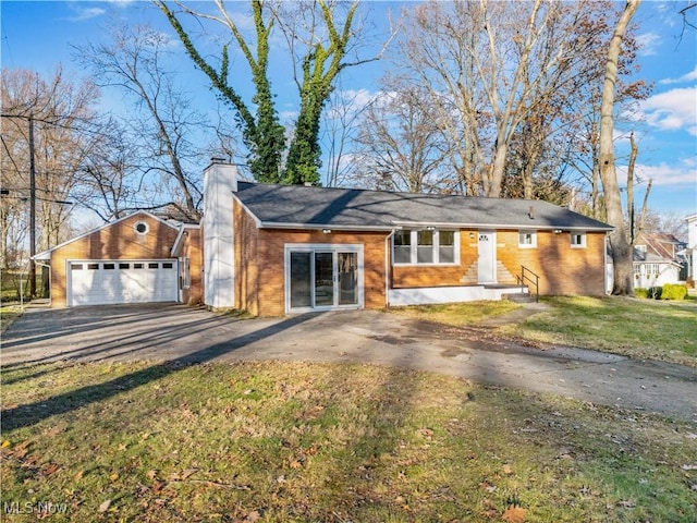 single story home with a garage, an outbuilding, and a front yard