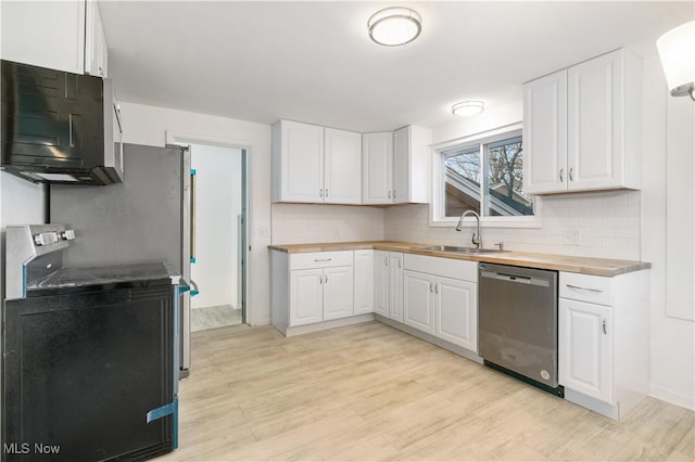 kitchen featuring sink, tasteful backsplash, butcher block countertops, white cabinetry, and stainless steel appliances