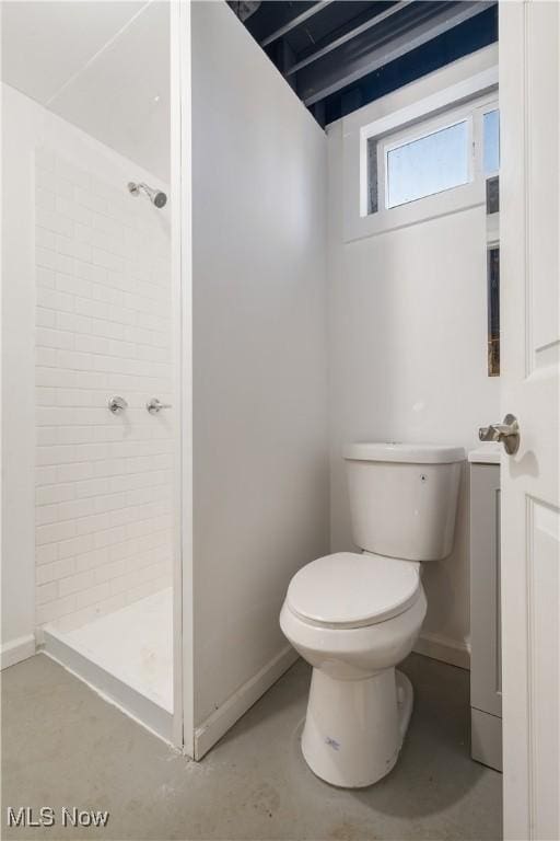 bathroom with a shower, concrete floors, and toilet