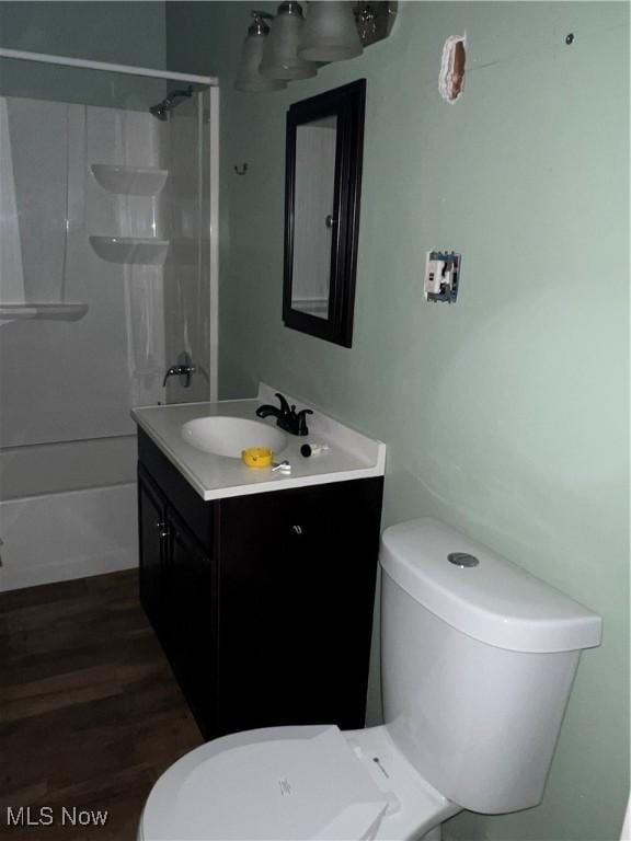 full bathroom featuring wood-type flooring, vanity, shower / bath combination, and toilet