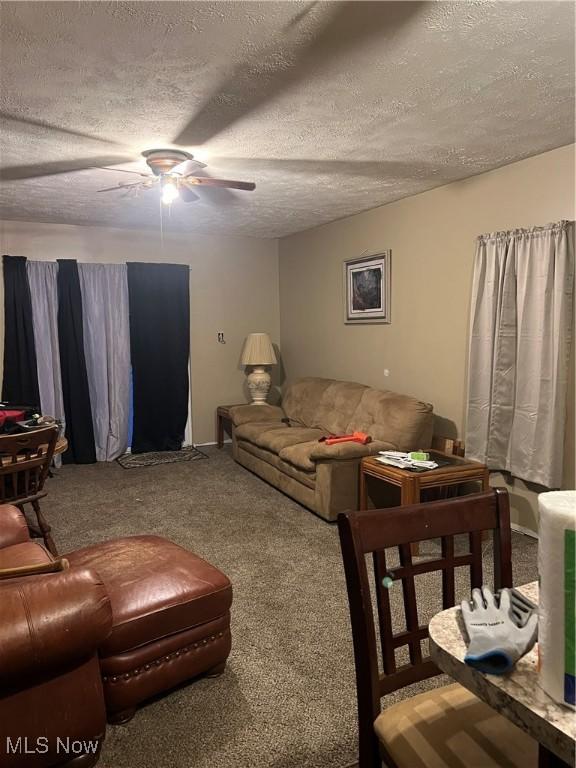 living room featuring carpet, a textured ceiling, and ceiling fan