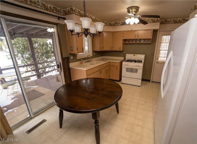 kitchen featuring a wealth of natural light, sink, ceiling fan with notable chandelier, and white appliances