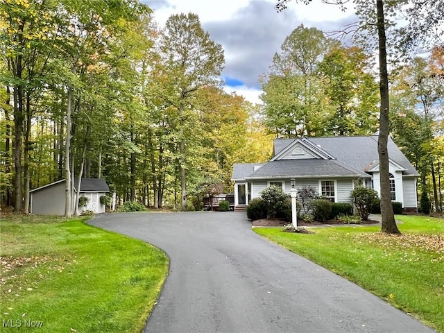 view of front facade featuring an outdoor structure, a front yard, and a garage