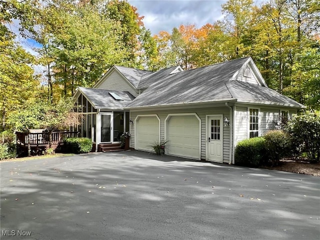 view of home's exterior with a wooden deck and a garage