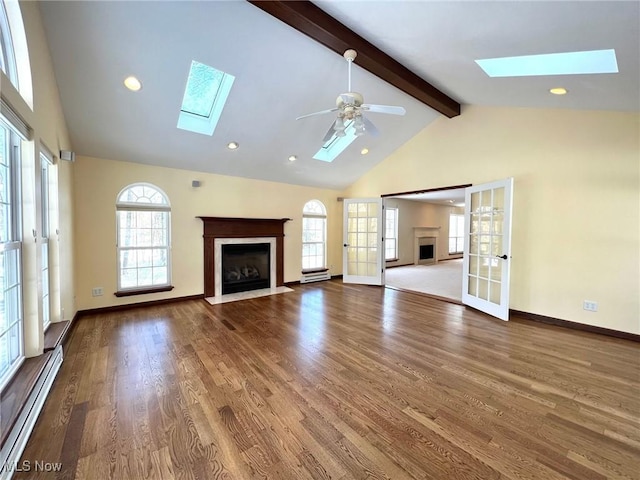 unfurnished living room with french doors, ceiling fan, a baseboard radiator, beam ceiling, and wood-type flooring